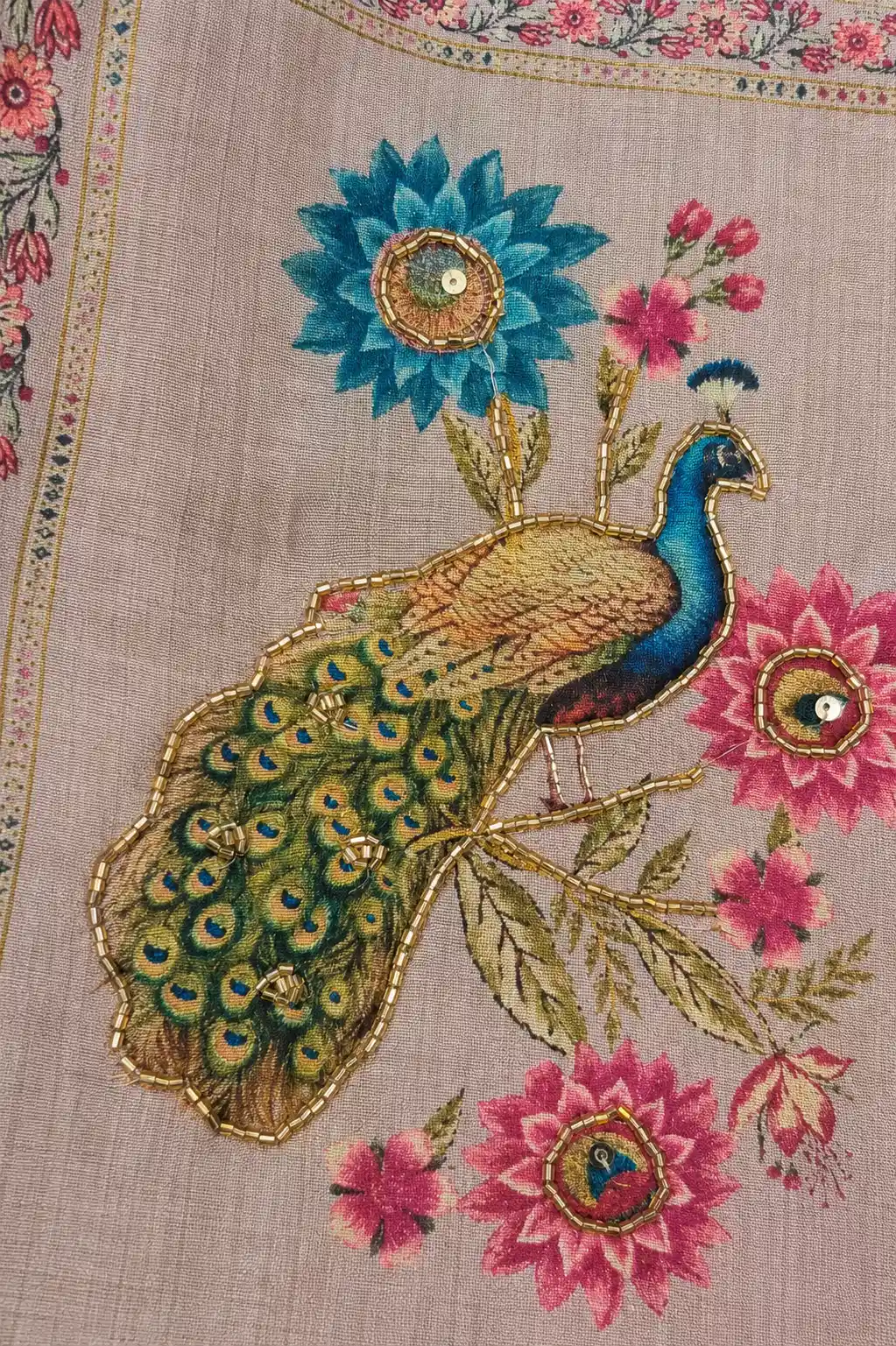 Close-up of the Morbagh silk suit’s printed peacock motif outlined with gold-toned beadwork and subtle sequin accents